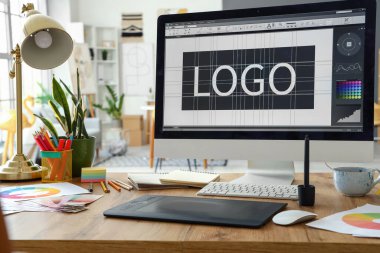 Ofiste bilgisayar, tablet ve boya paletleri ile grafik tasarımcısının çalışma yeri