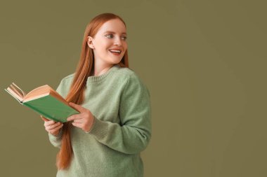 Yeşil arka plan üzerine kitap okuyan genç bir kadın.