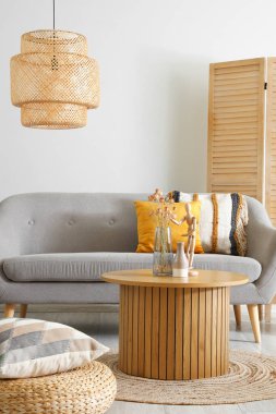 Ahşap manken ve vazo. Oturma odasının iç tarafındaki sehpada kurumuş çiçekler var.