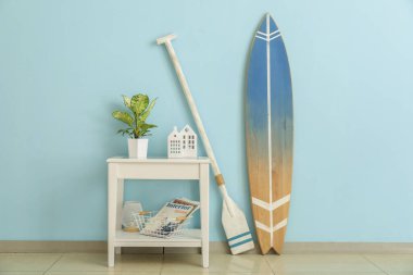 Sörf tahtası, küreği ve masası olan bir oda.