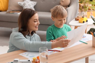 Evde çizim yapan küçük çocukla dadı.