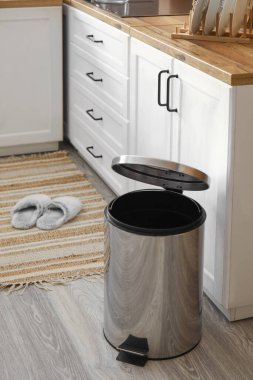 Modern mutfağın zemininde metalik çöp kutusu açıldı.
