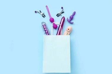 Mavi arka planda seks oyuncakları olan bir alışveriş çantası.