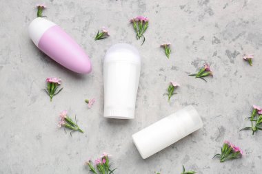 Grunge arka planında farklı deodorantlar ve çiçekler