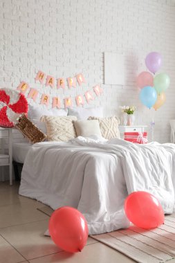 Yatak odasının içi balonlar, pinyatalar ve çelenklerle süslenmiş.