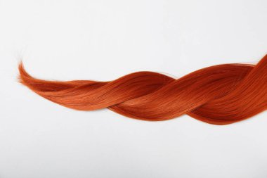 Beyaz arka planda kızıl saç örgüsü, yakın plan.