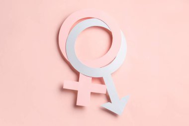 Pembe arka planda kadın ve erkeğin kağıt sembolleri.