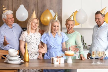 Olgun insanlar mutfakta doğum gününü kutluyor.