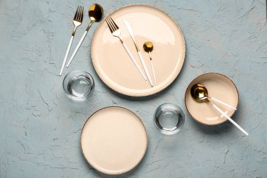 Gri grunge masasında temiz tabak, bardak ve çatal bıçak takımı.