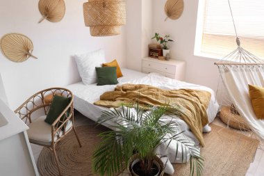 Rahat yatağı, hamağı ve bitkisi olan çocuk odasının içi.