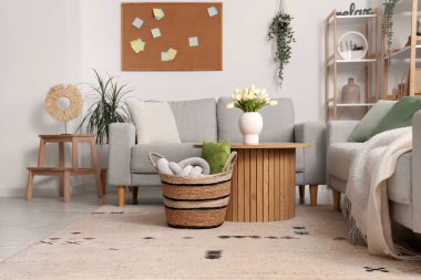 Kanepeleri, masası ve sepeti olan aydınlık oturma odasının içinde.