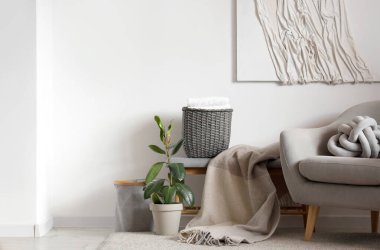 Koltuk ve hasır sepetli, aydınlık oturma odasının içi