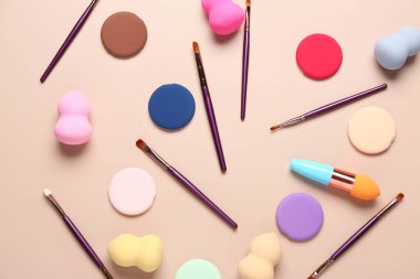 Bej arka planda makyaj süngerleri ve fırçalar