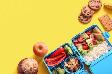 Sarı arka planda farklı lezzetli yemekleri olan beslenme çantaları.