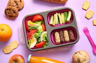 Lezzetli yemekler ve leylak arkaplanda bir şişe meyve suyu.