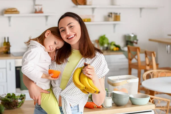 小女孩和妈妈在厨房里吃着健康的水果 — 图库照片