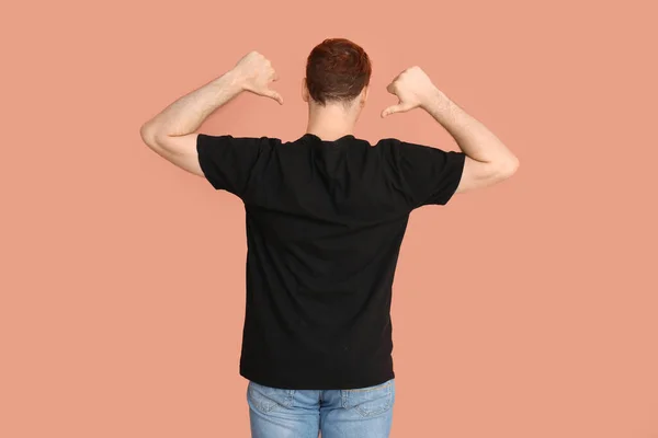 Jovem Apontando Para Sua Camiseta Preta Fundo Bege Vista Traseira — Fotografia de Stock