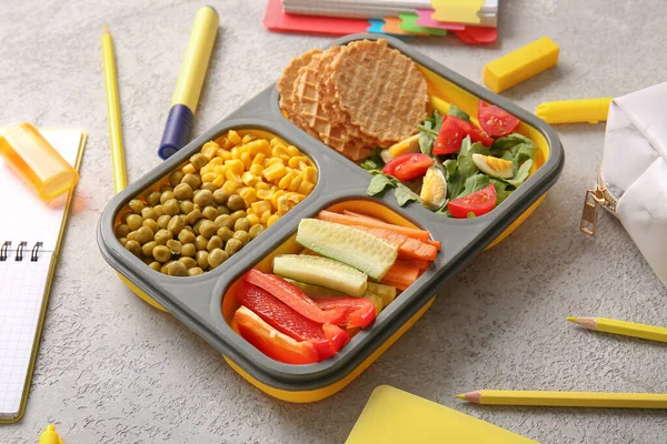 Lunchbox Pysznym Jedzeniem Różnymi Materiałami Piśmiennymi Grunge Szarym Tle — Zdjęcie stockowe