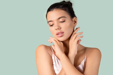 Yeşil arka planda güzel dudakları olan genç bir kadın, yakın plan.