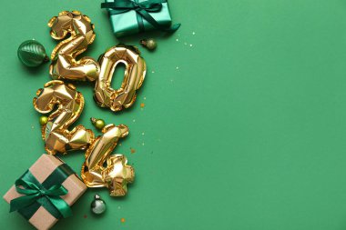 Şekil 2024 hediye kutuları ve yeşil arka planda Noel süsleri olan balonlardan yapılmış.
