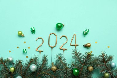 Noel süslemeleri ve turkuaz arka planda köknar dalları olan kıvılcımlardan yapılmış figür 2024