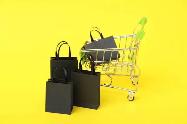 Shopping Cart Bags Yellow Background Closeup Black Friday Concept — Stock Photo, Image