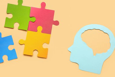 Bej arka planda yapboz parçaları olan kağıt insan kafası. Mantık kavramı