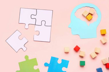 Pembe arka planda küpler ve yapboz parçaları olan kağıt insan kafası. Mantık kavramı