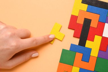 Bej arka planda blokları olan bir kadın, yakın plan. Mantık kavramı