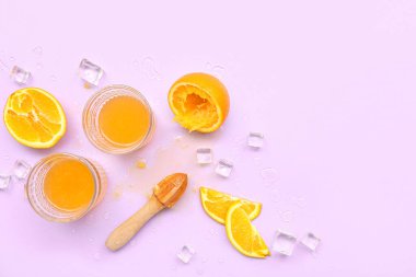 Buzlu portakal suyu ve leylak arkaplanlı meyve sıkacağı.