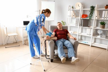 Klinikte olgun donörden kan alan kadın hemşire.