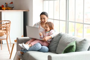 Annesiyle birlikte evde çizgi film izleyen küçük bir kız.