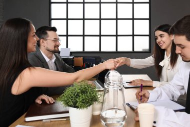 İnsan kaynakları müdürü, kadın başvuru sahibinin elini sıkıyor.