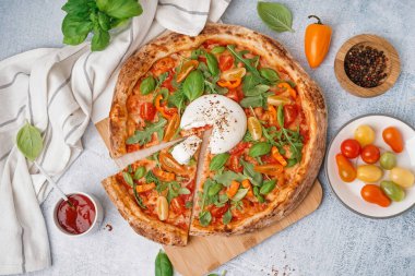 Gri arka planda Burrata peynirli lezzetli pizza.