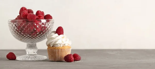 Tasty cupcake and fresh raspberry on table. Banner for design
