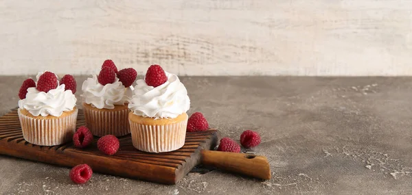 Tasty raspberry cupcakes on table. Banner for design