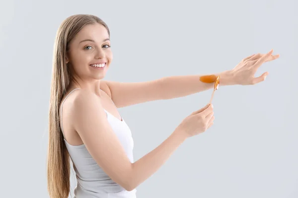 Young Woman Applying Sugaring Paste Arms Light Background — Stock Photo, Image