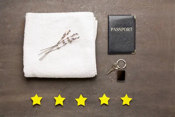 Five stars with towel, key from hotel room and passport on dark background. Customer experience concept