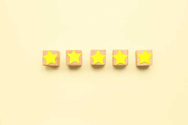Five cubes with stars on beige background. Customer experience concept