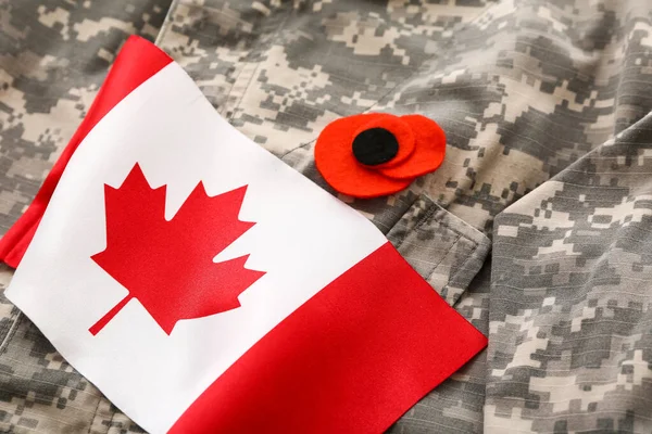 Poppy flower and flag of Canada on military uniform, closeup. Remembrance Day