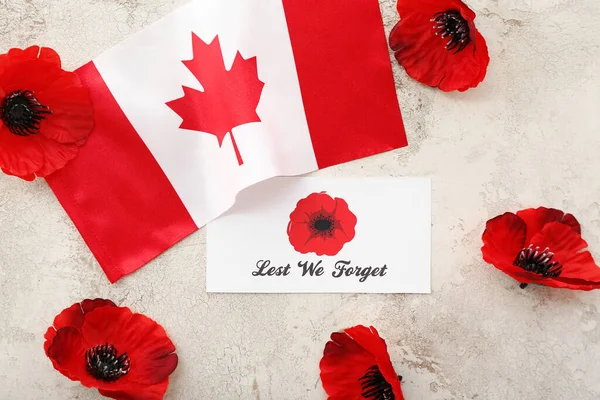 Poppy flowers, flag of Canada and card on light grunge background. Remembrance Day