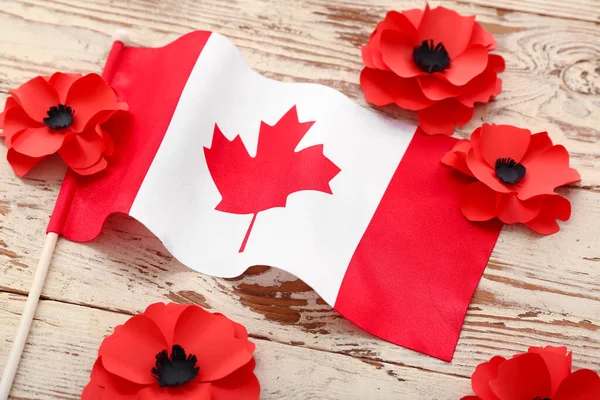 轻质木制背景上有加拿大国旗的罂粟花 纪念日 — 图库照片