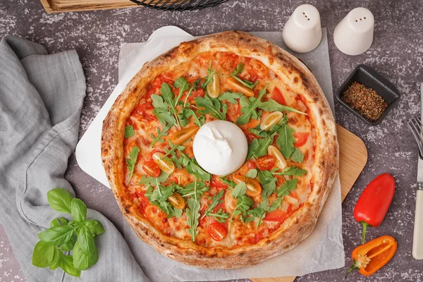 Gri arka planda Burrata peynirli lezzetli pizza.