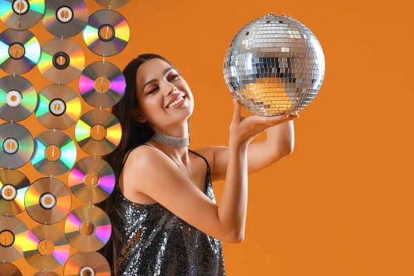 Stylish Young Woman Disco Ball Compact Disks Orange Background — Stock Photo, Image