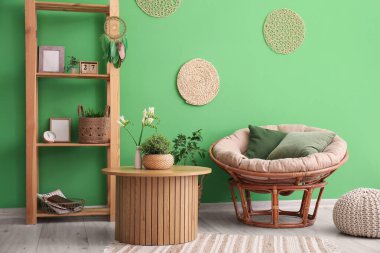 Oturma odasının içinde rüya yakalayıcı, koltuk ve raf ünitesi var.