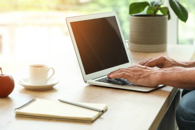 Bilgisayarlı olgun bir adam mutfakta mesajlaşıyor, yakın plan.