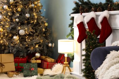 İçinde Noel ağacı, hediye kutuları, parlayan lamba ve şömine olan oturma odası.