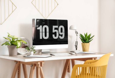 Işık ofisinde bilgisayar monitörü ve yapay tesisleri olan modern işyeri