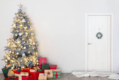 İçinde hediyeler olan Noel ağacı oturma odasının içinde