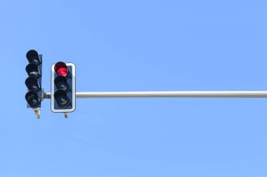 Mavi gökyüzüne karşı kırmızı trafik ışığının görüntüsü